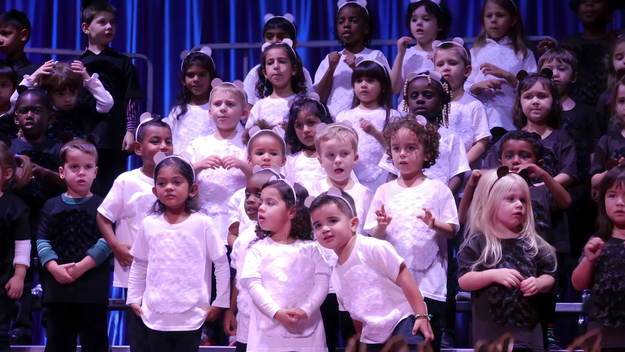 Young students in white and black performing on stage
