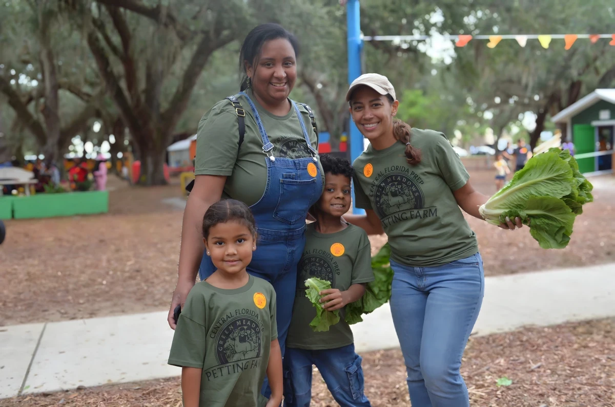 Two teachers with students at the garden beds